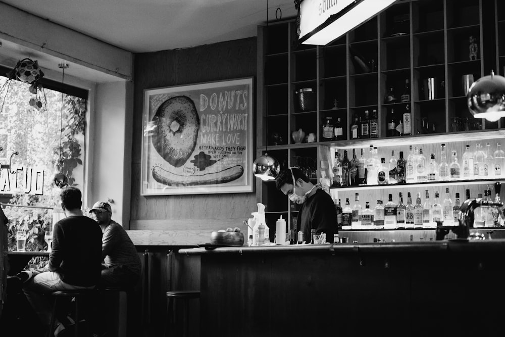 grayscale photo of man and woman sitting on chair