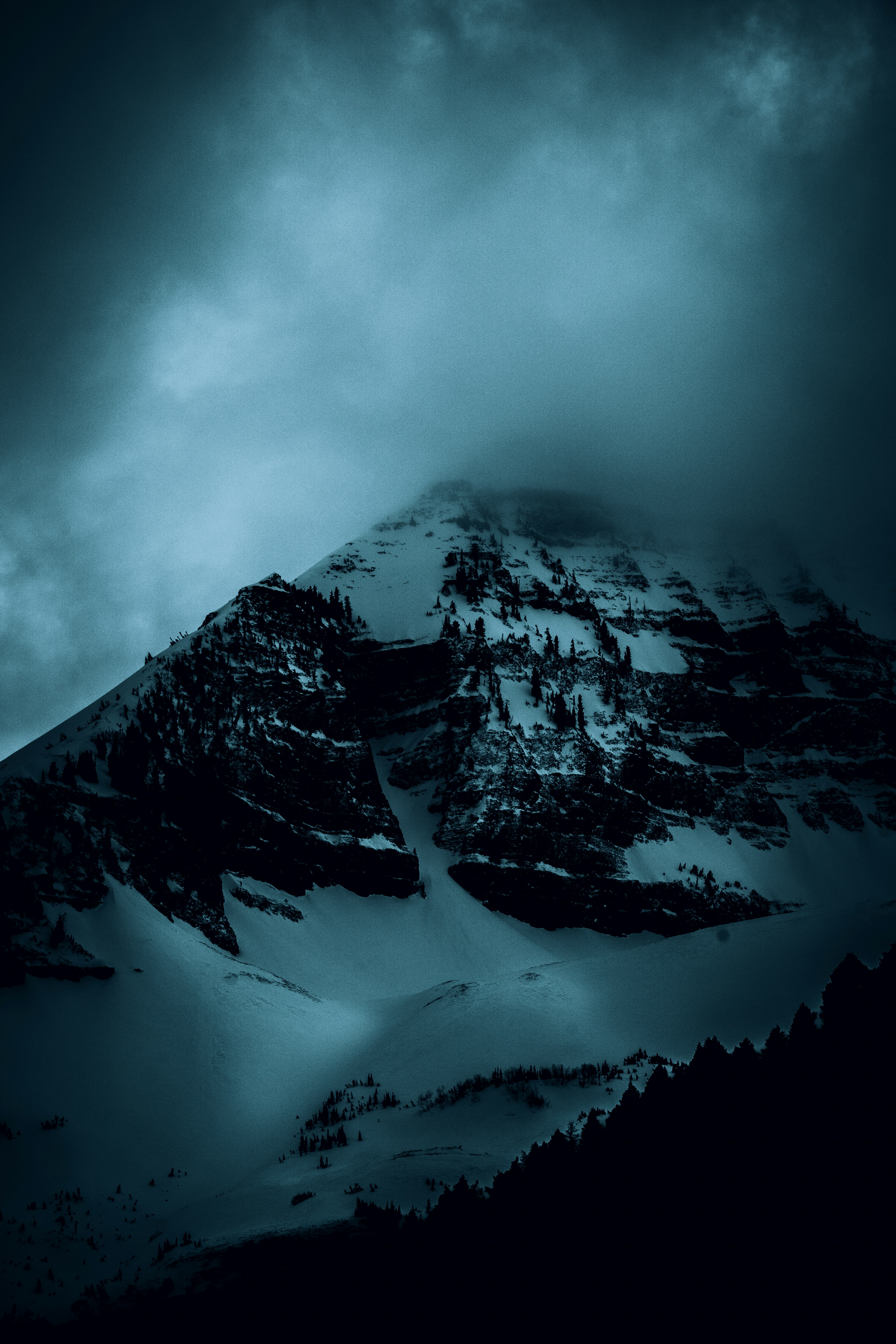 snow covered mountain under cloudy sky