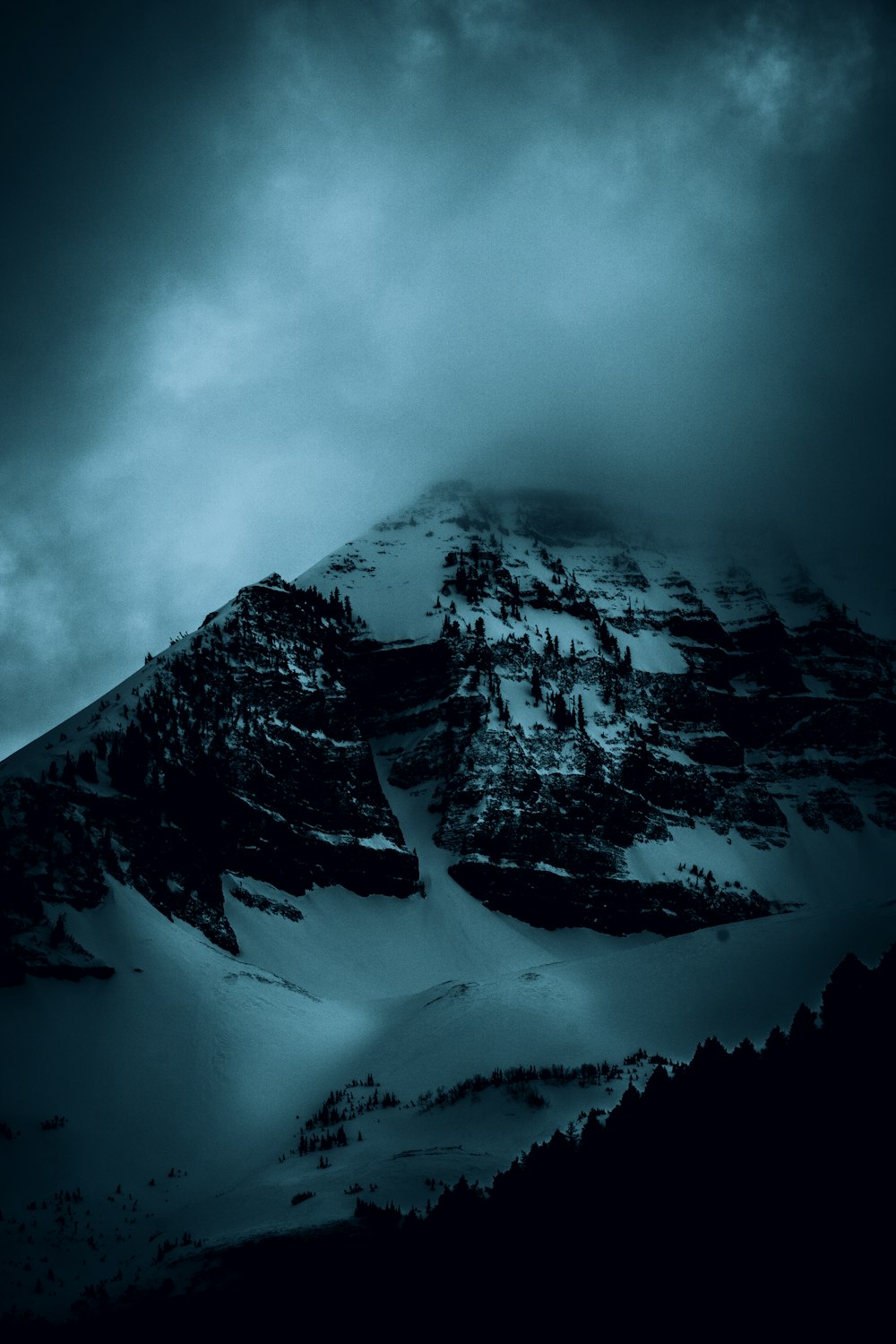 schneebedeckter Berg unter bewölktem Himmel