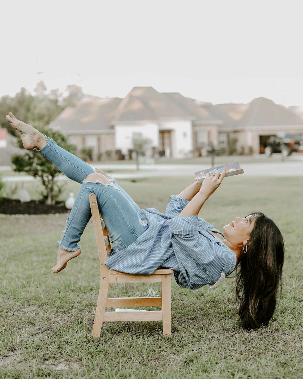 woman in blue denim jeans sitting on brown wooden chair