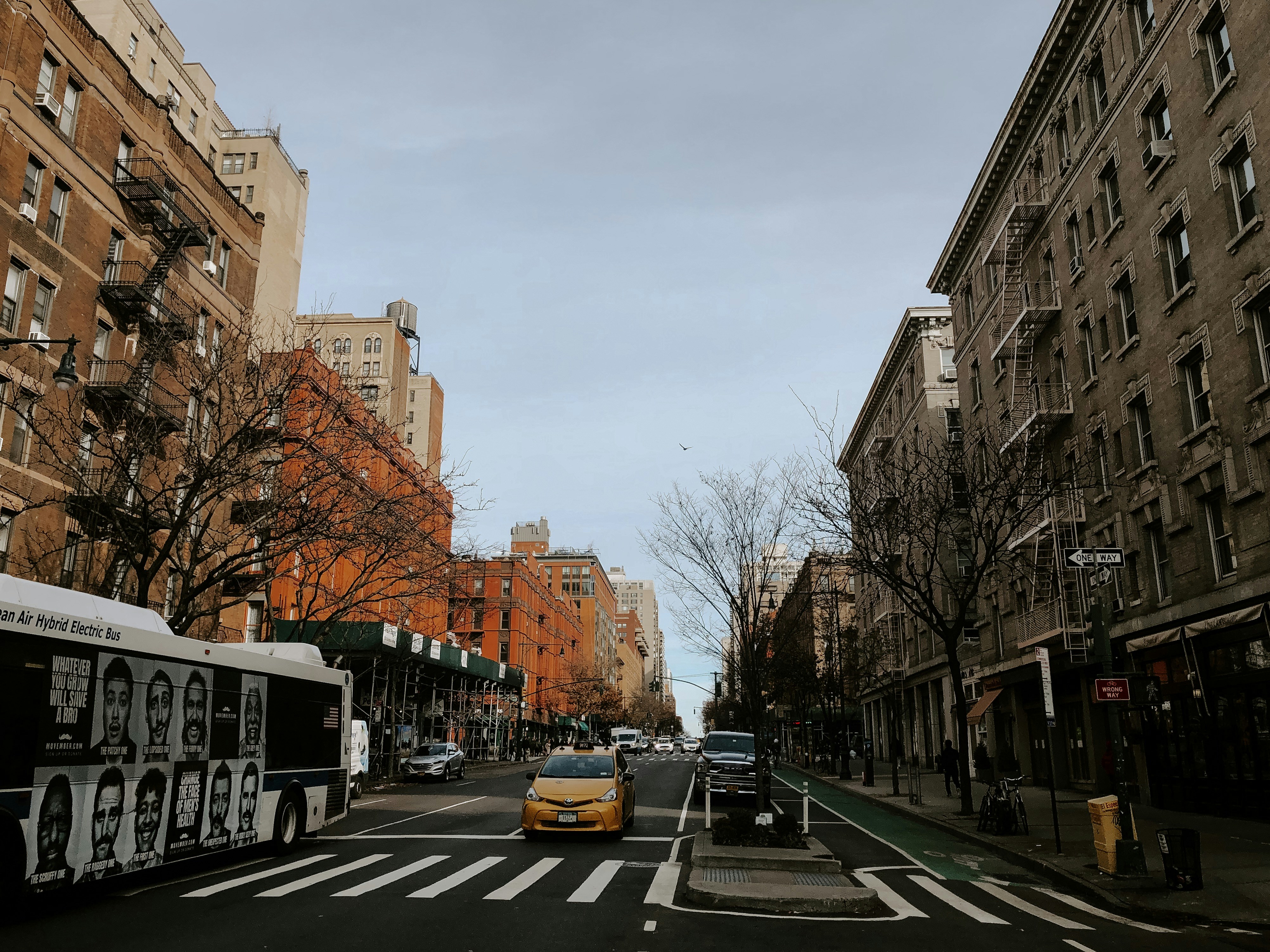 cars parked on side of the road near buildings during daytime