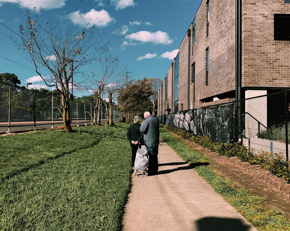 Hombre con chaqueta gris caminando por el camino durante el día