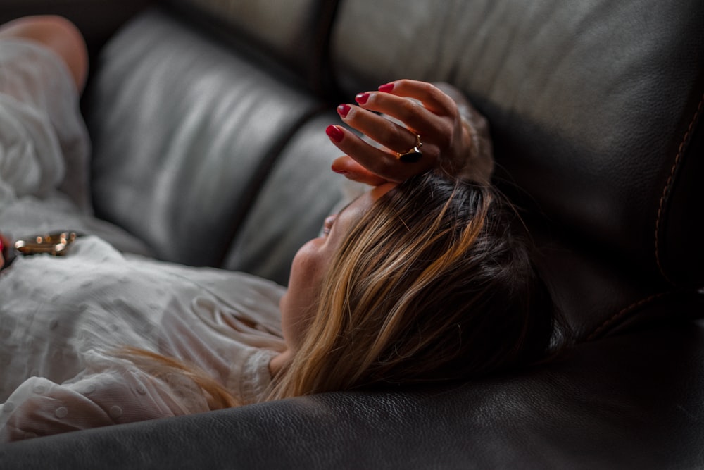 woman lying on gray couch