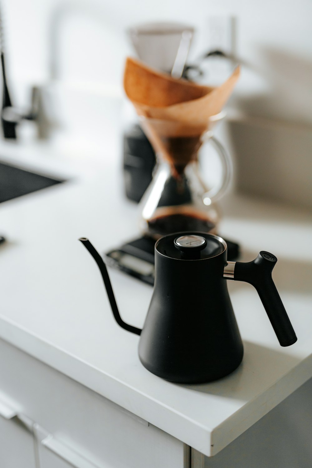black ceramic teapot pouring brown liquid on black ceramic mug