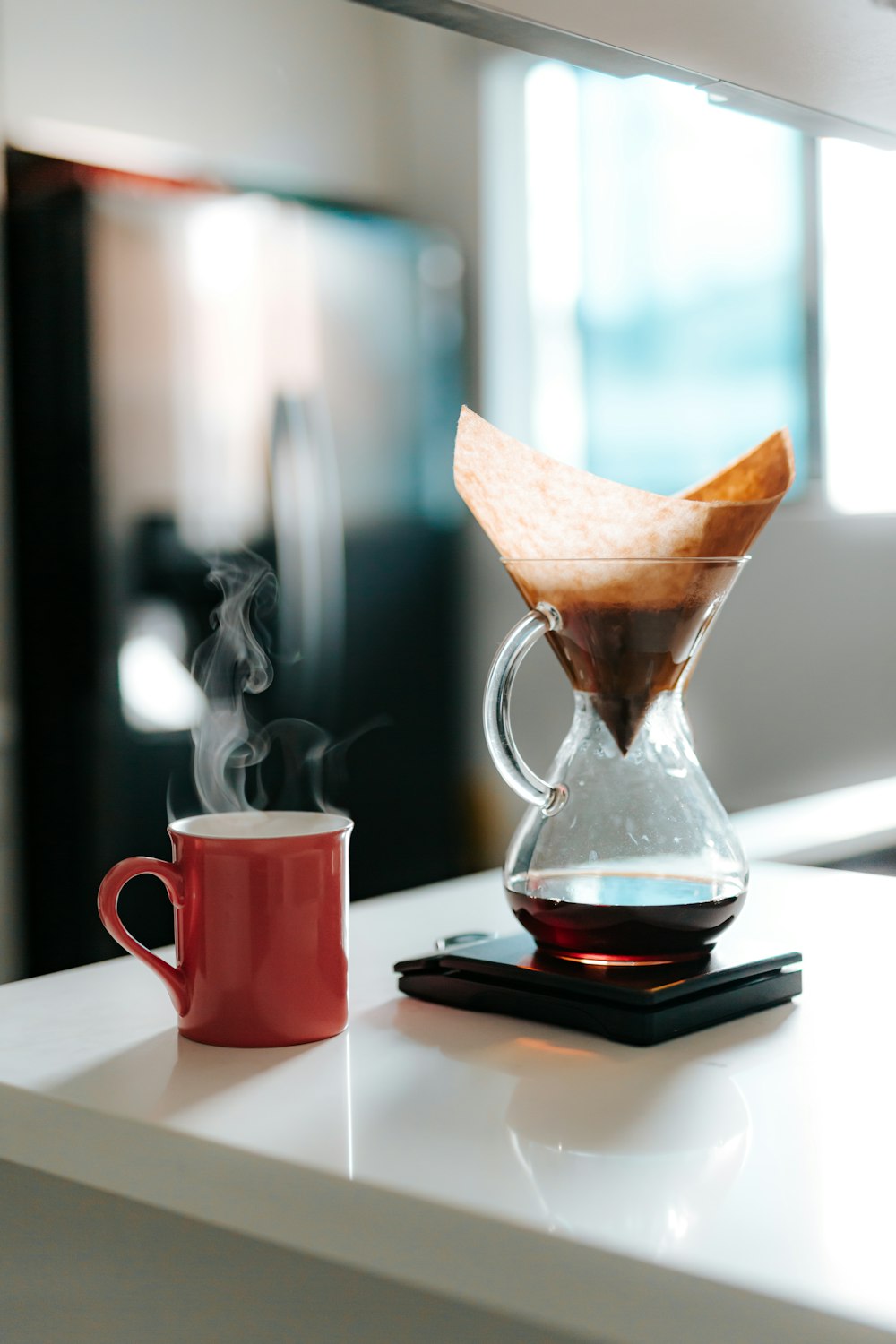 red ceramic mug with brown liquid inside