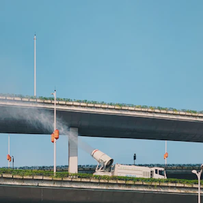 white and black airplane on gray concrete bridge under blue sky during daytime