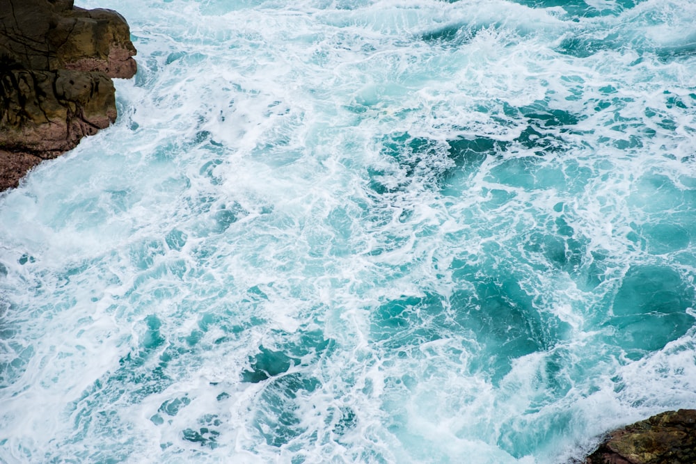 ocean waves crashing on rocky shore during daytime