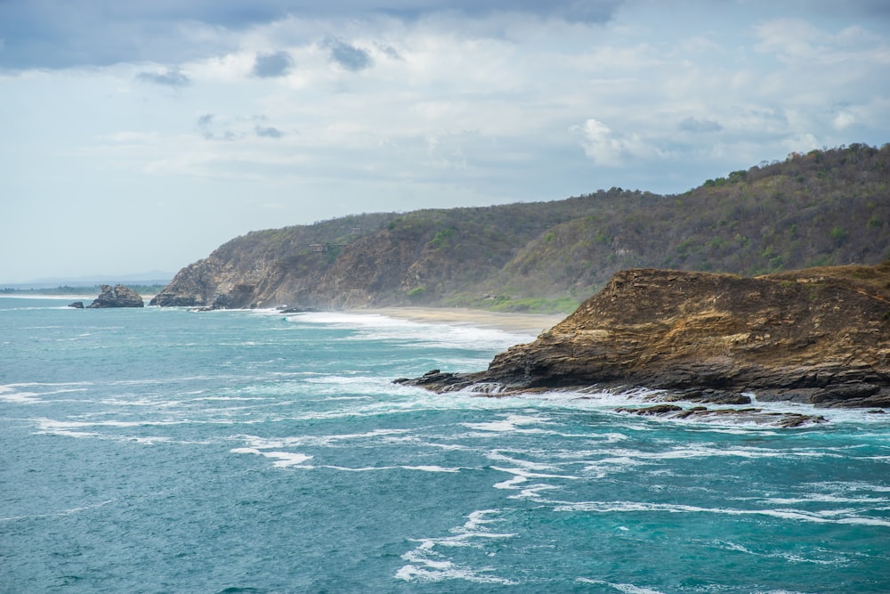 green and brown island on blue sea under white clouds and blue sky during daytime