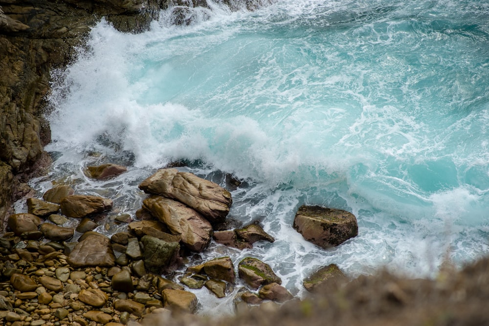 brown rocks on body of water during daytime