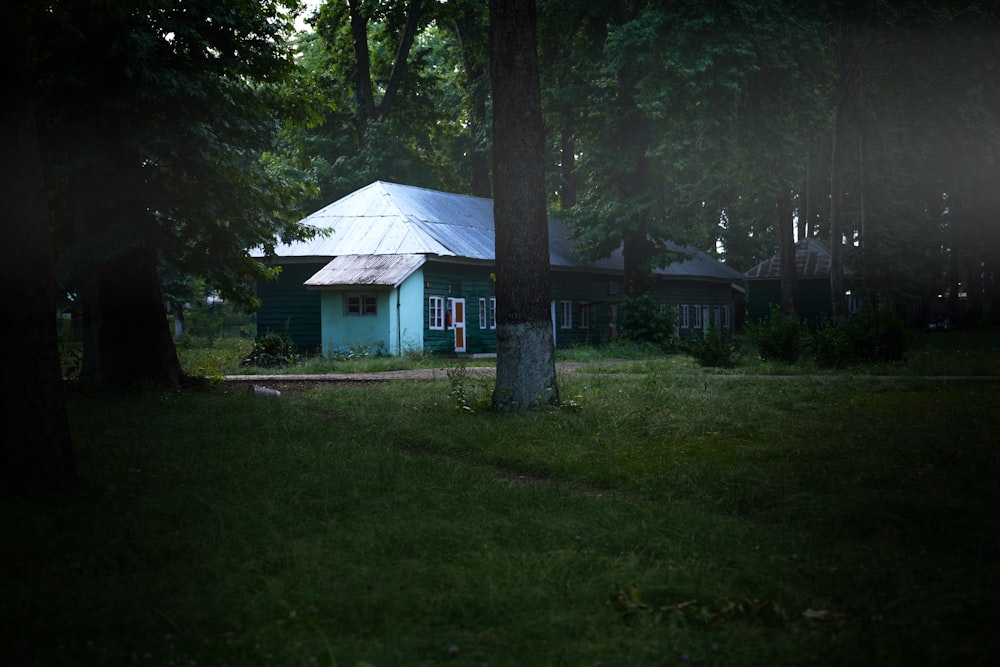 푸른 나무로 둘러싸인 흰색과 갈색 목조 주택