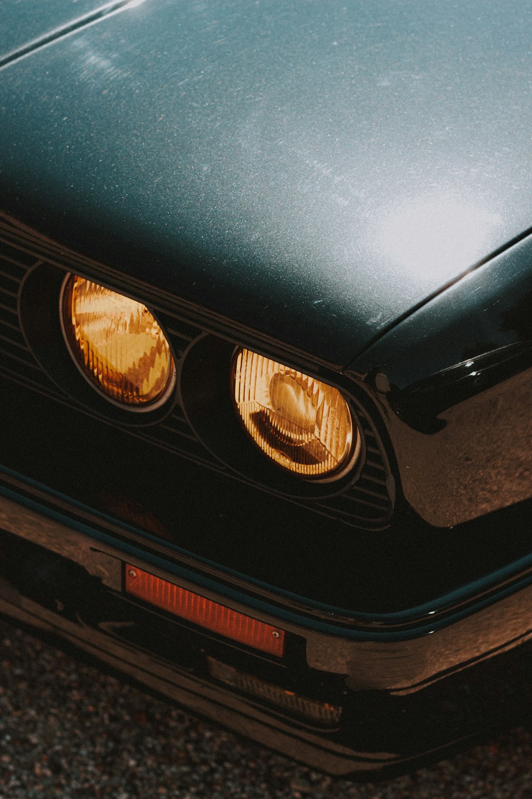 green car with white and brown lights