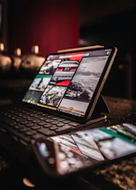 A friendly person typing on a laptop with images displayed on the screen.