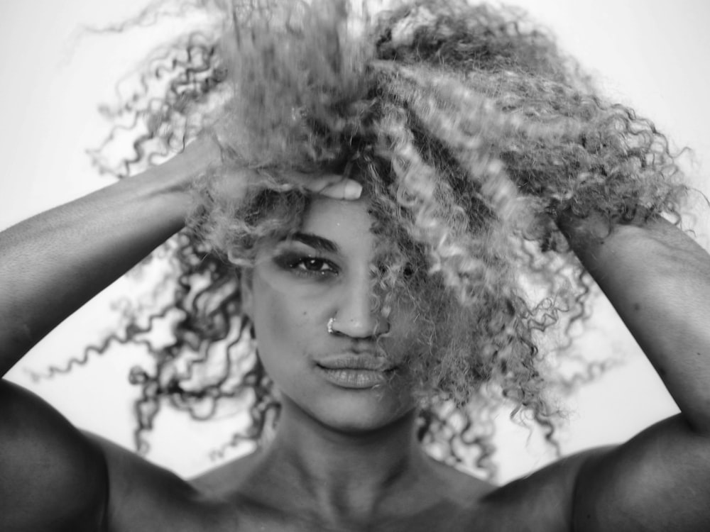 grayscale photo of woman with curly hair