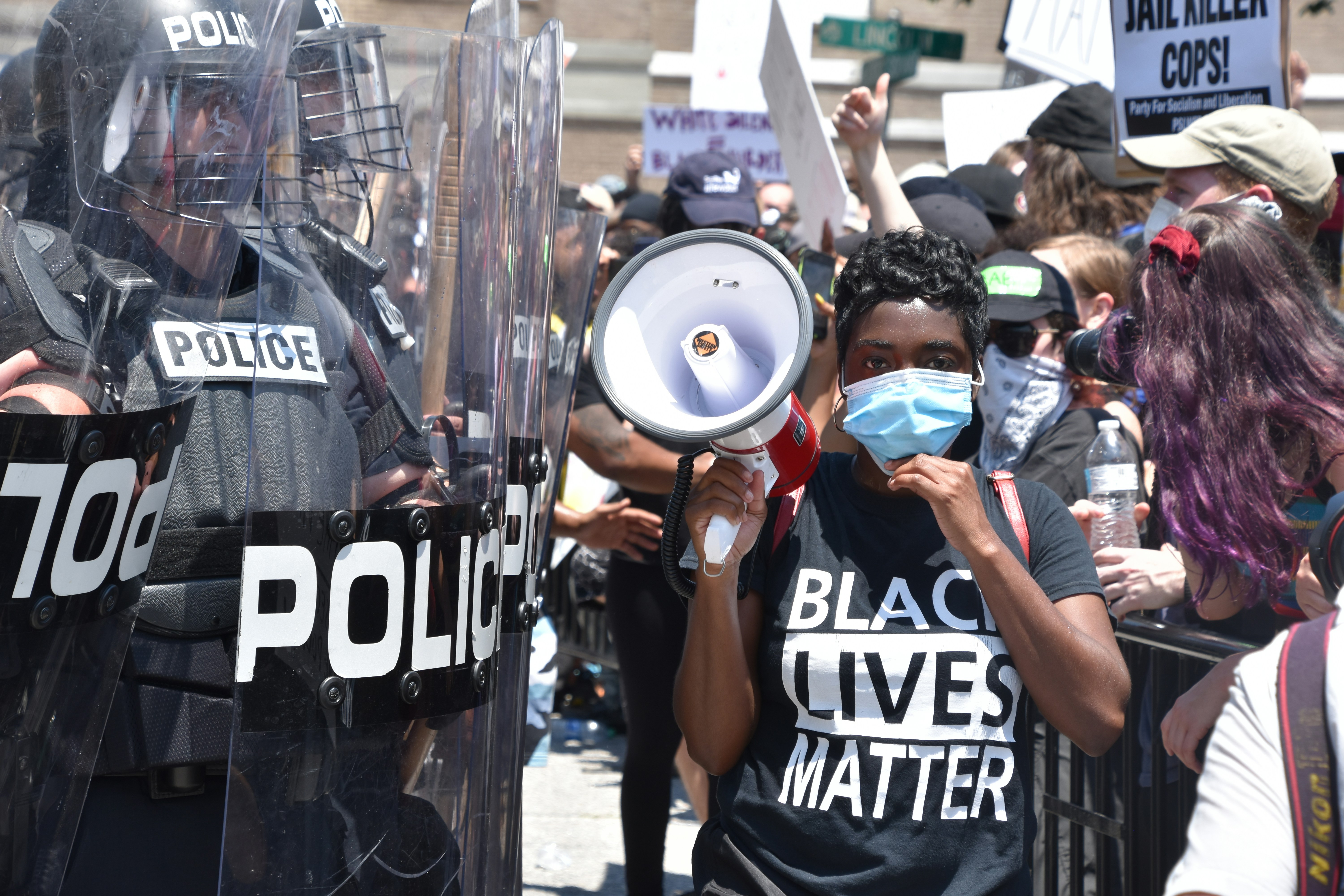 man in black and white t-shirt wearing blue and white mask