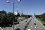 Wide road flanked by streetlights and drainage system in a commercial plot area.