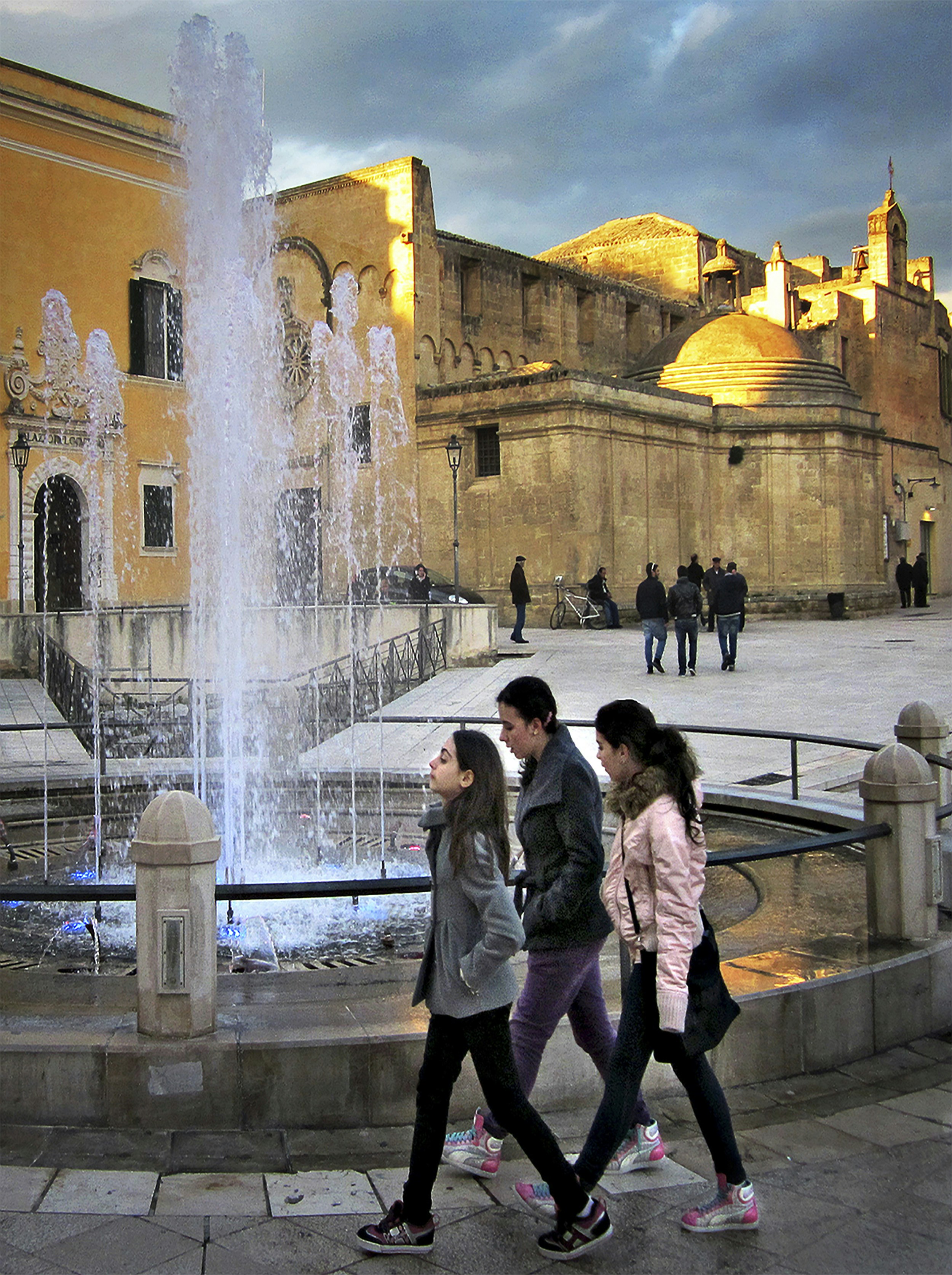 woman in gray coat standing near fountain