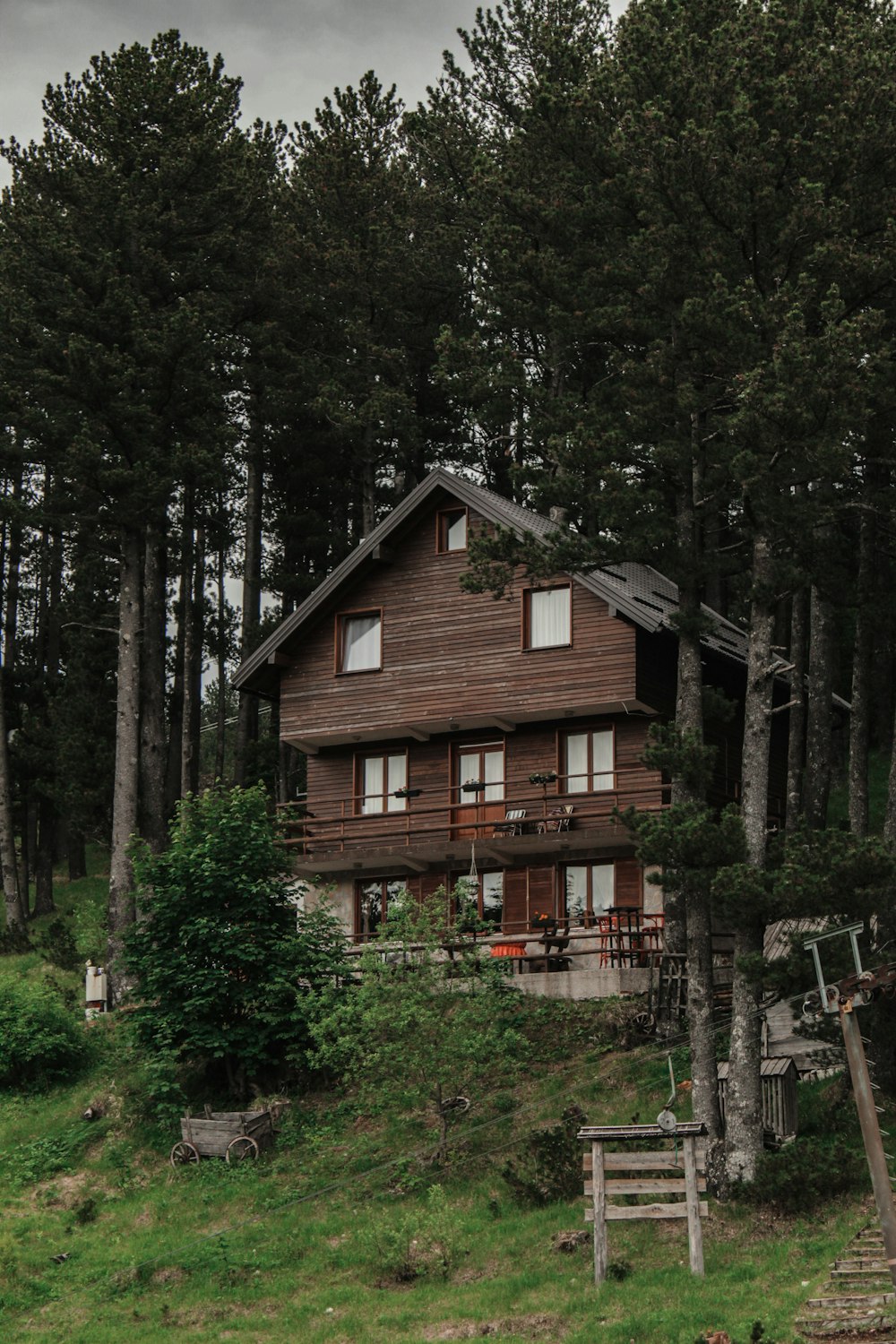 brown wooden house surrounded by green trees during daytime