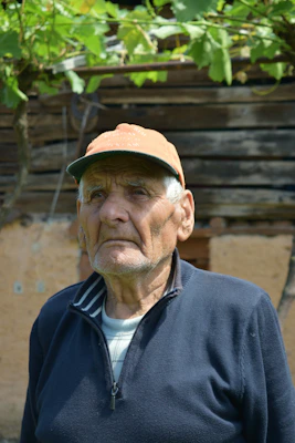 homme en veste noire zippée et chapeau marron