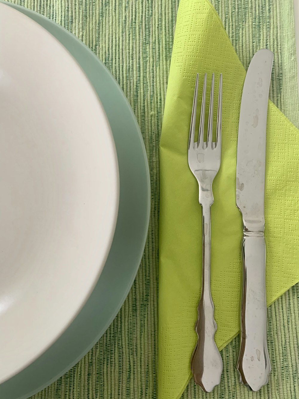 silver fork and bread knife on white ceramic plate