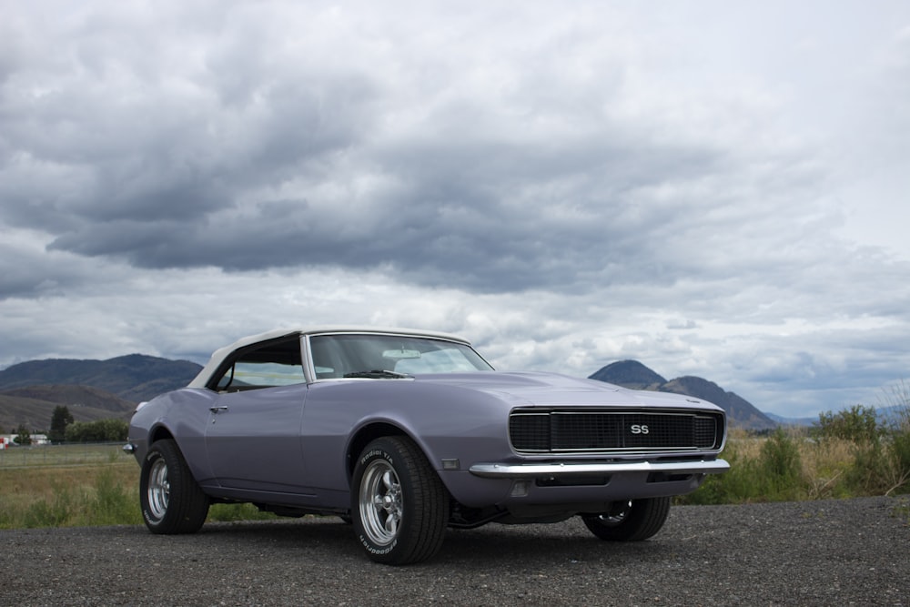 blue chevrolet camaro on green grass field during daytime