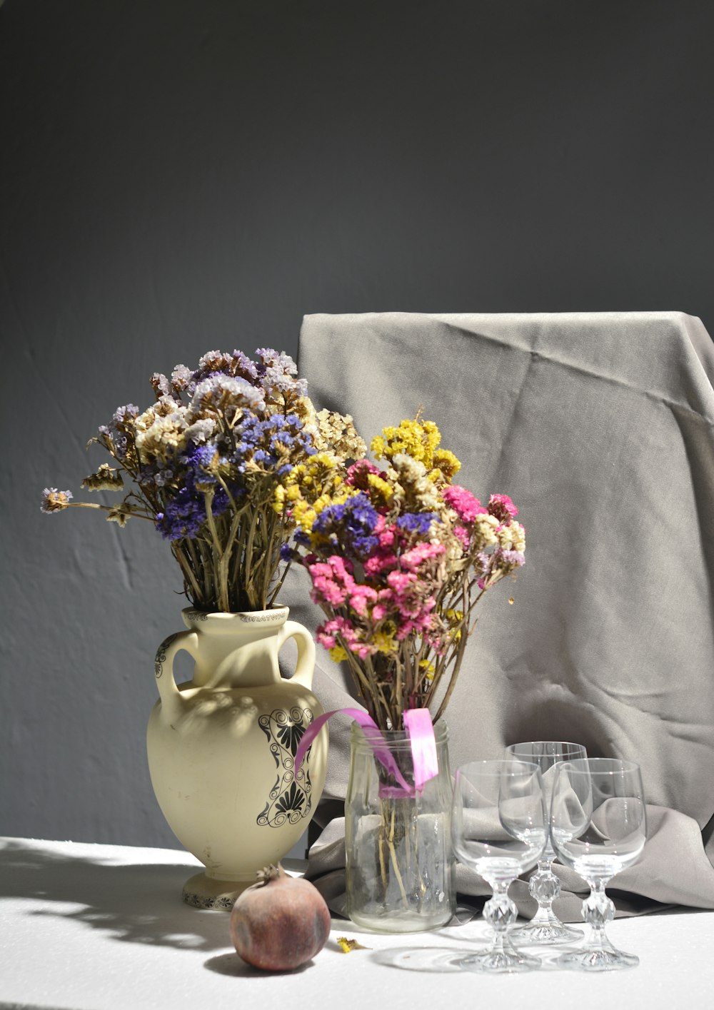 purple and yellow flowers in white ceramic vase