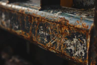 Close-up of peeling paint and rust on an abandoned metal door, revealing layers of time.