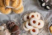 A delicate arrangement of maamoul cookies dusted with powdered sugar, resting on a gold-trimmed tray.