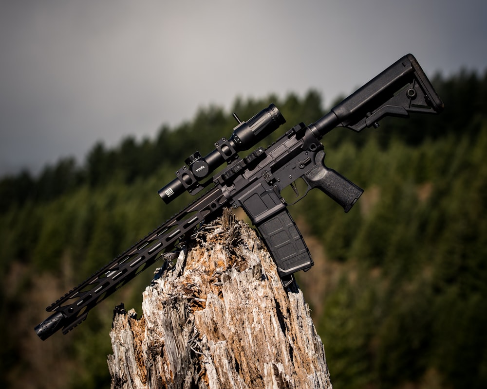 Schwarzes Sturmgewehr auf braunem Holz