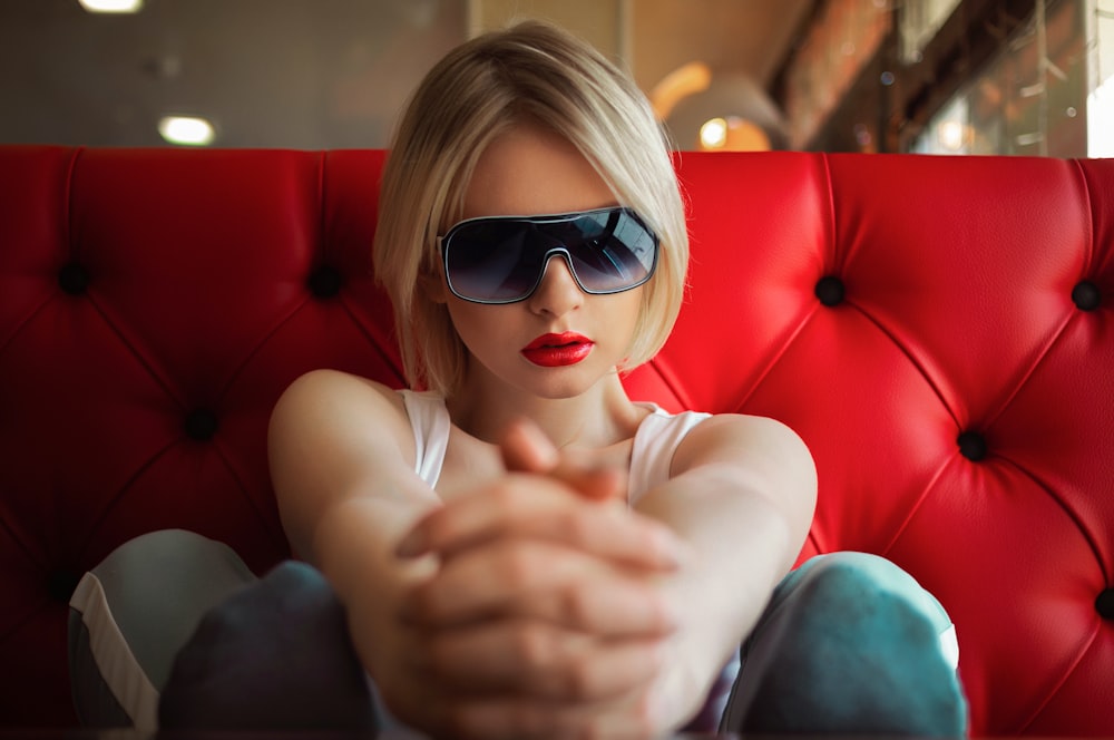 Frau im weißen Tanktop mit schwarzer Sonnenbrille