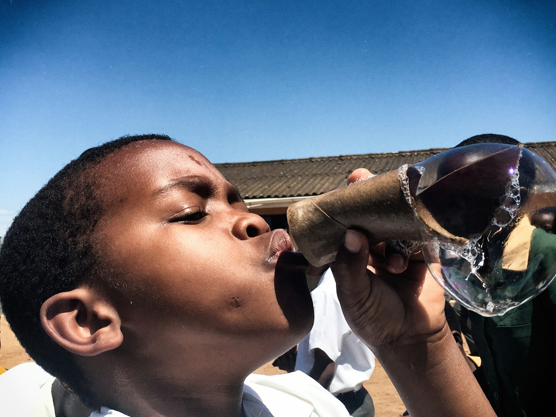 boy in white shirt drinking water from bottle