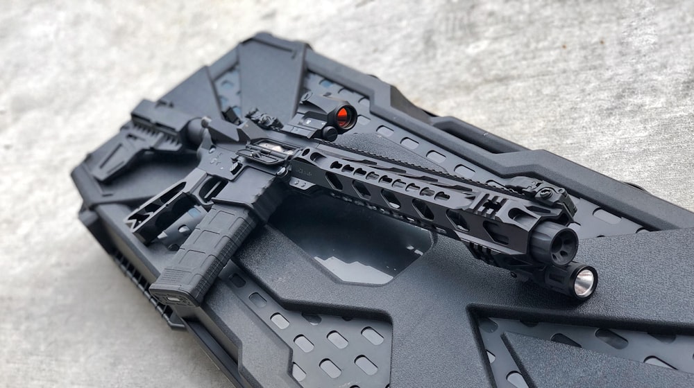 Fusil noir sur étui en plastique noir