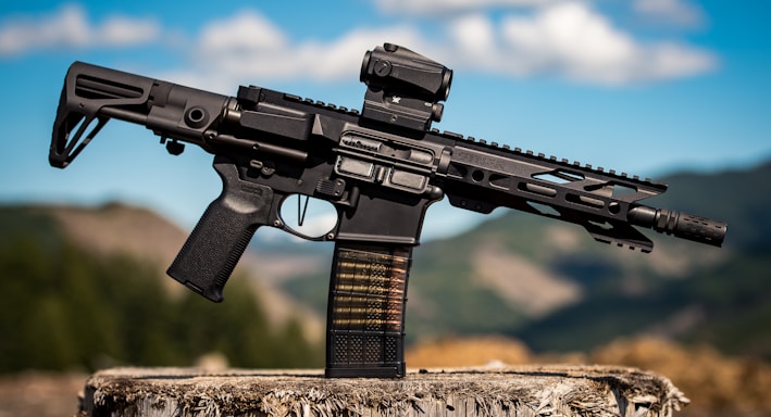 black assault rifle on brown wooden log