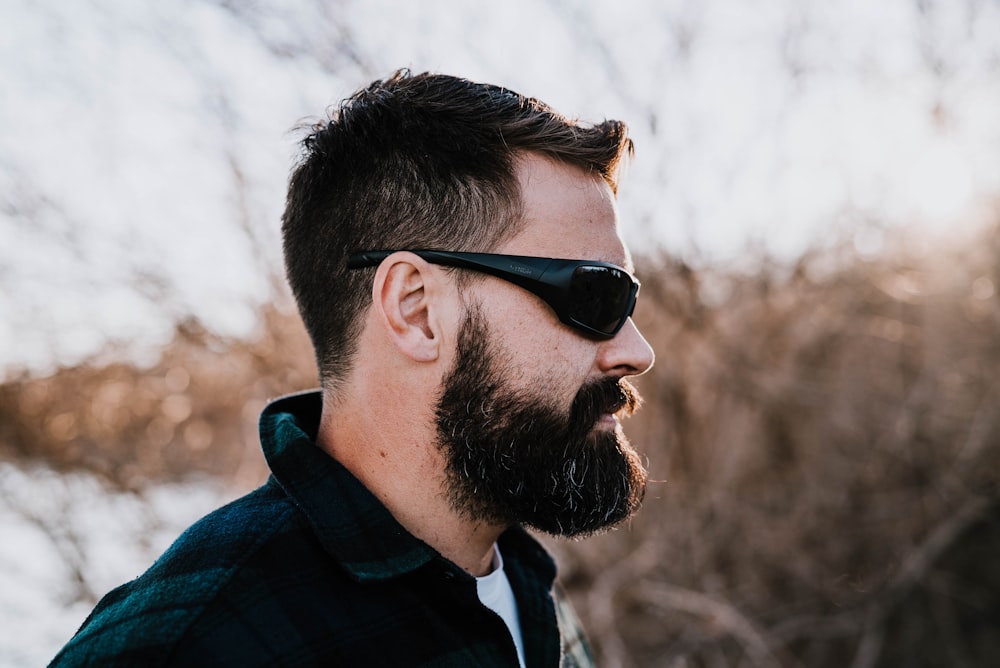 Hombre con chaqueta azul y negra con gafas de sol negras