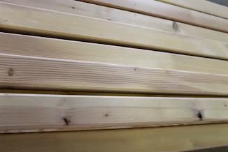 Close-up of smooth, polished wooden planks stacked neatly in a workshop.