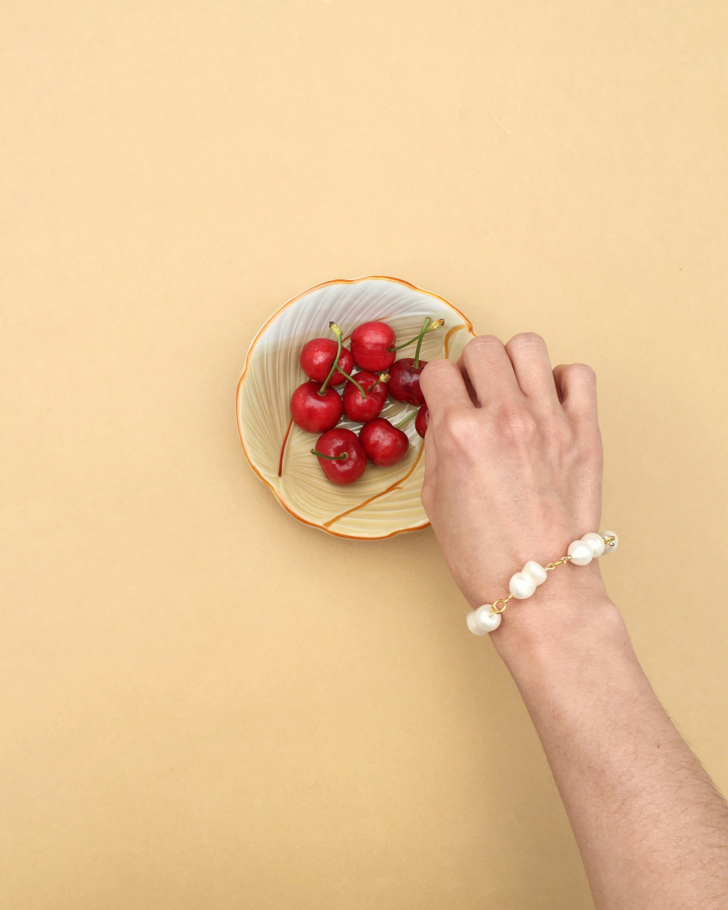 person holding red round fruit