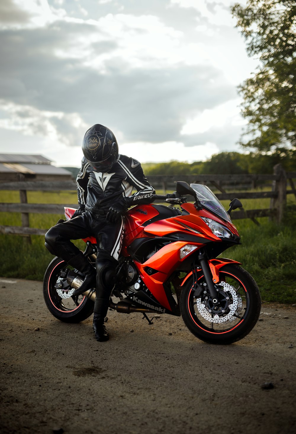 man in black helmet riding orange sports bike