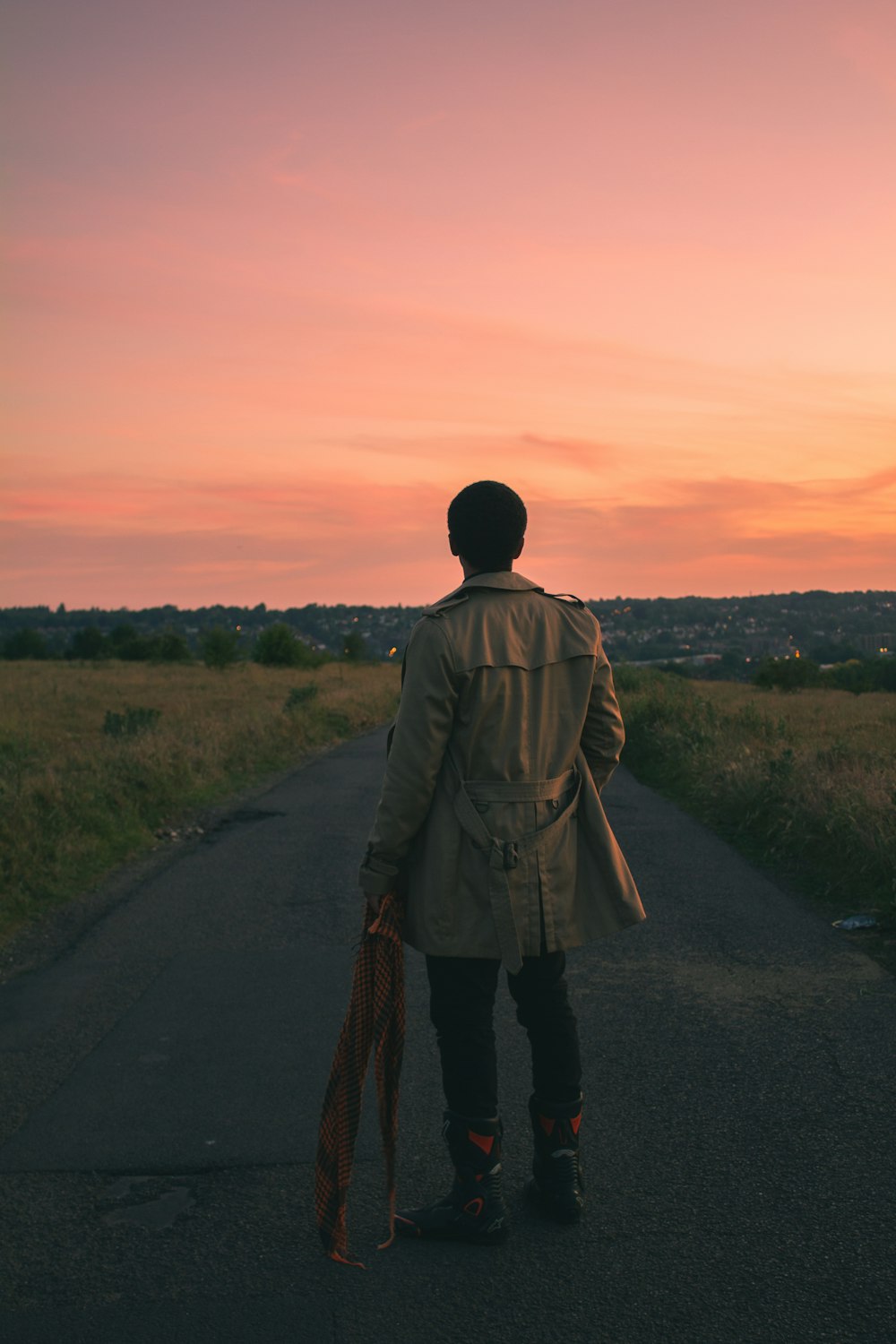 man in brown coat walking on road during daytime