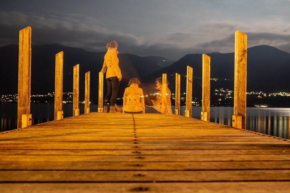 couple walking on wooden dock during daytime