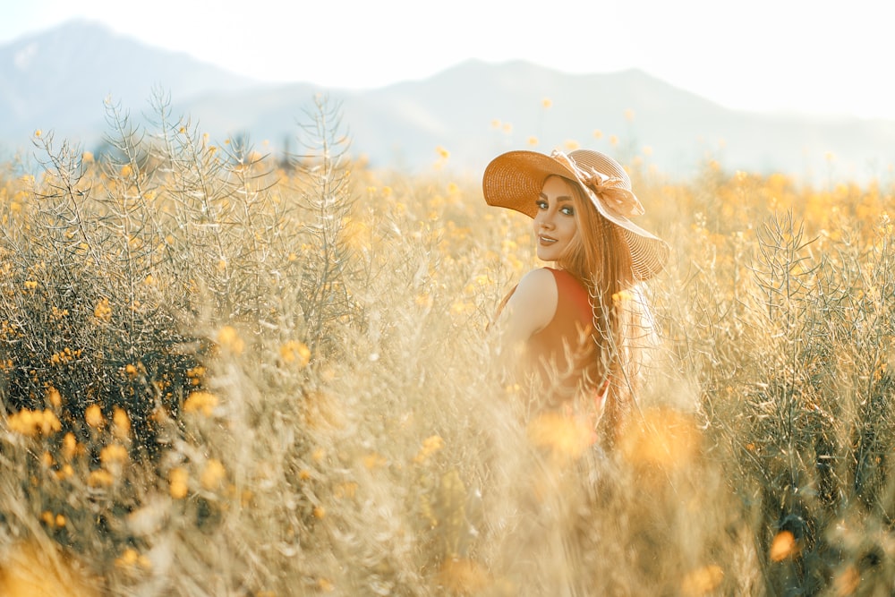 woman in brown sun hat standing on brown grass field during daytime