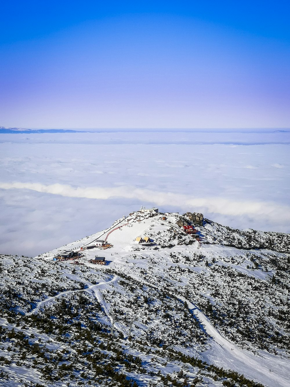 snow covered mountain near body of water during daytime