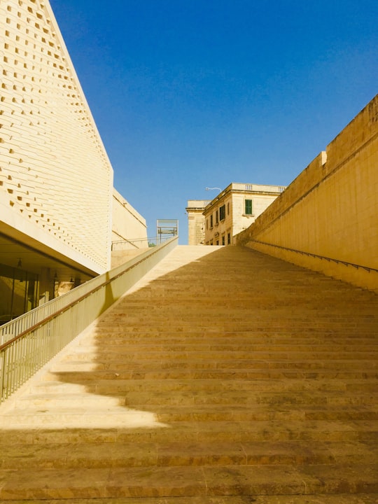 brown concrete building under blue sky during daytime in Valletta City Gate Malta