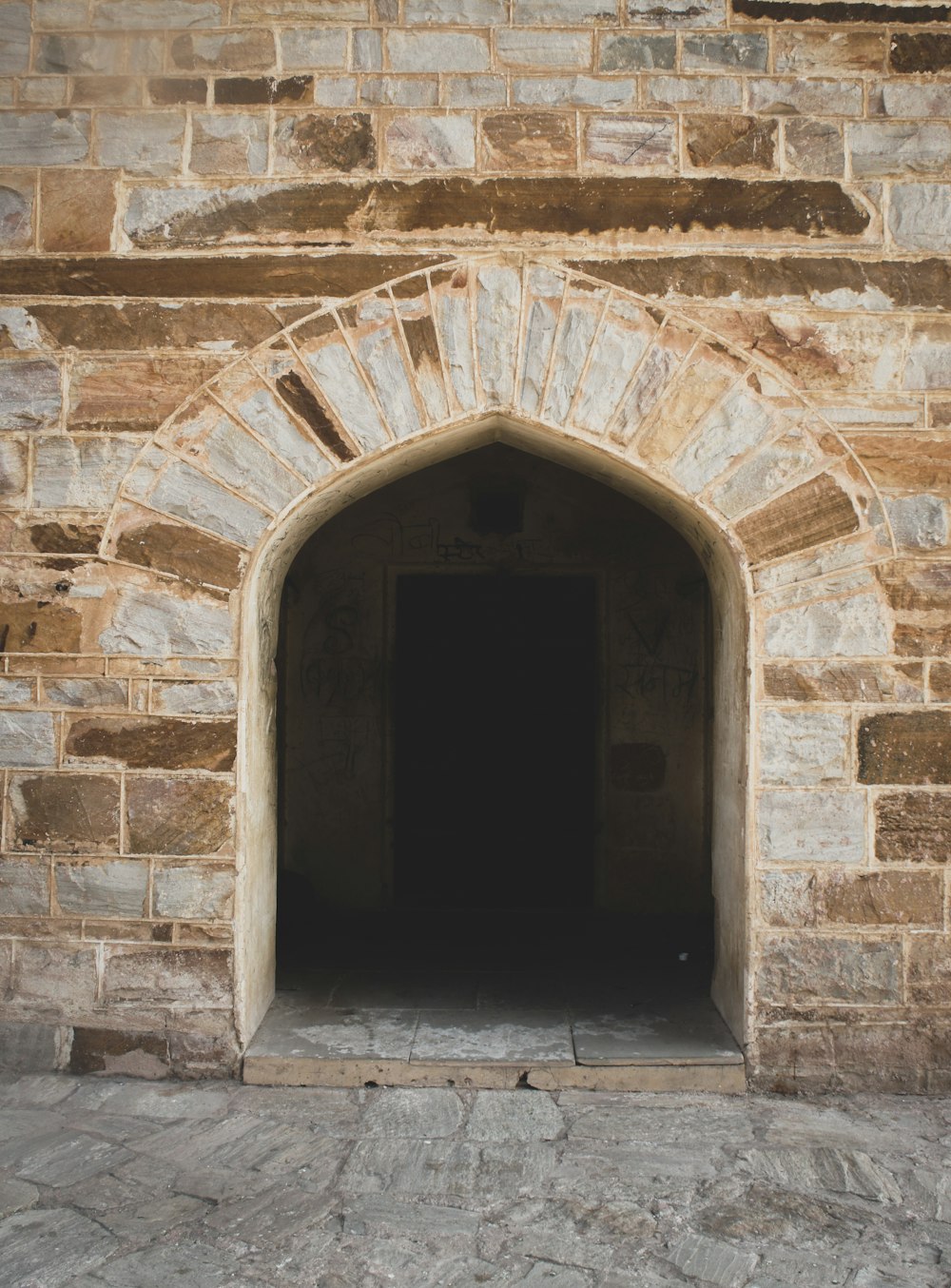 brown brick wall with black door