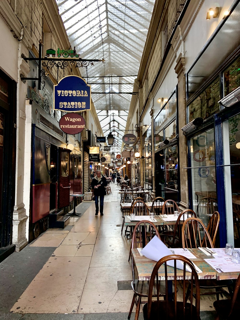 brown wooden table and chairs near store during daytime