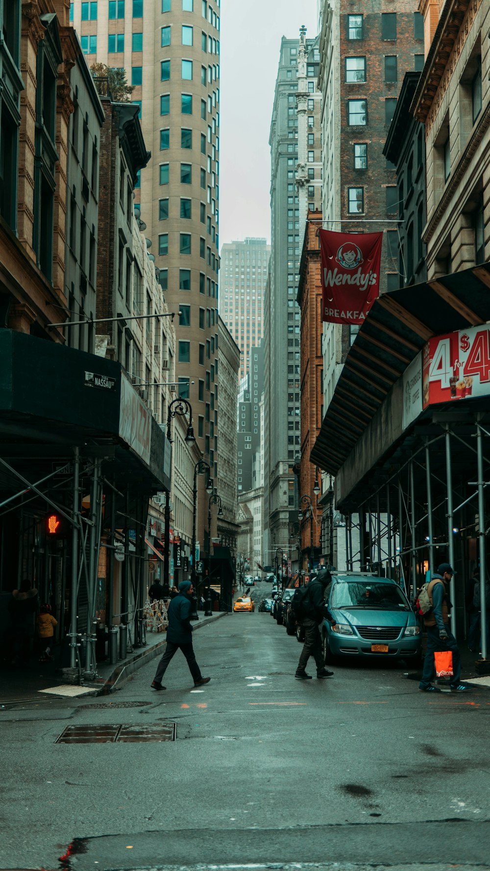 cars on road between high rise buildings during daytime