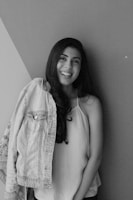 A smiling girl posing in casual chic daily wear against a vibrant wall.