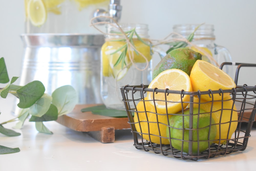 green lemon fruit in black metal basket