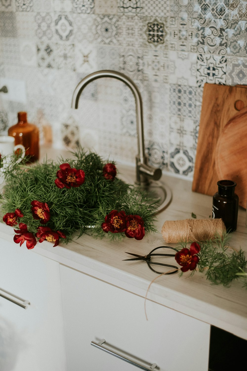 grüner und roter Weihnachtskranz auf braunem Holzschneidebrett