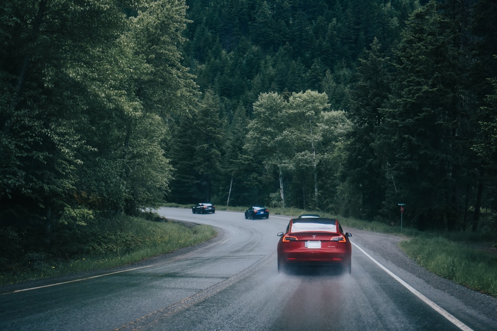 red car on gray asphalt road during daytime