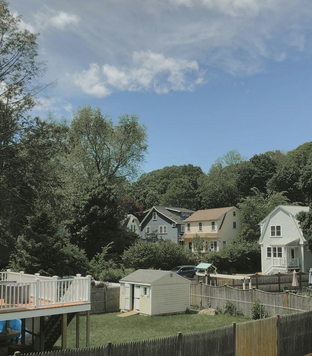 white and brown houses near green trees under blue sky during daytime