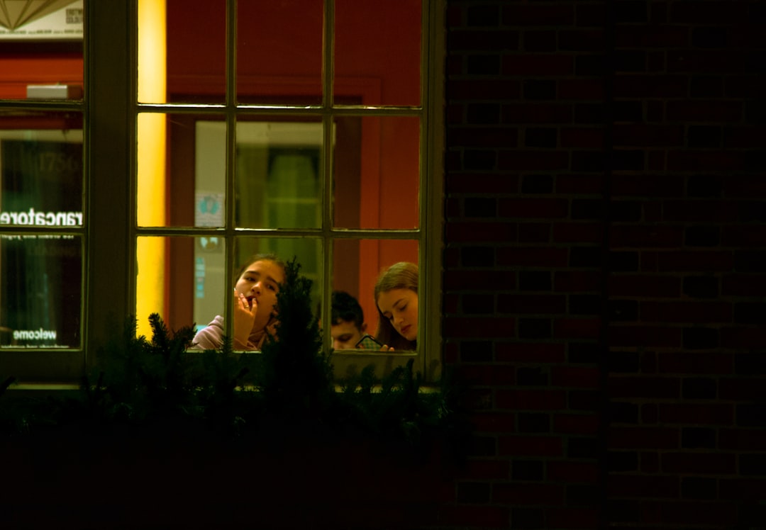 2 women standing beside window